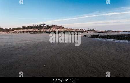 Pier sulle rocce si vede dalla sabbia con la bassa marea sulla spiaggia di Sanlucar de Barrameda Foto Stock