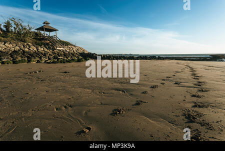 Pier sul Seawall sulla spiaggia di Sanlucar de Barrameda e impronte nella sabbia Foto Stock