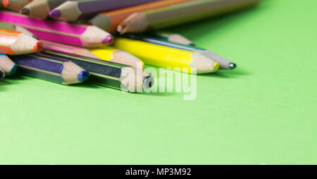 Molto usato matite di colori diversi isolati su uno sfondo verde. Concetto di ricambio per acquistare di nuove Foto Stock