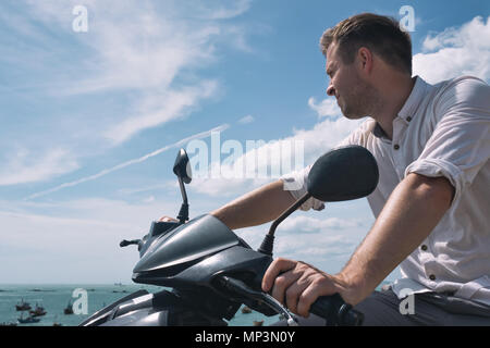 Uomo caucasico senza casco sedersi sulla moto. Foto Stock