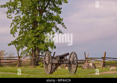 Un cannone a Gettysburg National Battlefield con una staccionata in legno e un albero in background Foto Stock