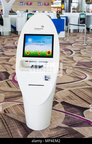 Un chiosco di colore bianco che effettua il check-in self-service al Terminal 4 dell'aeroporto Changi. Singapore. Foto Stock