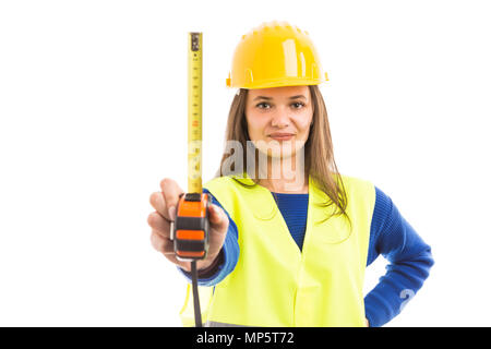 Giovane donna ingegnere o architetto tenendo verticale del nastro di misurazione come strumento professionale concetto isolato su sfondo bianco Foto Stock