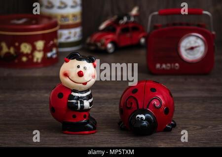 Ladybug figurine con macchie nere sul marrone sullo sfondo di legno Foto Stock