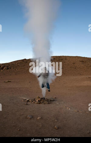 Giovane uomo a geyser Sol de Manana a Eduardo Avaroa fauna Andina riserva nazionale in Bolivia Foto Stock