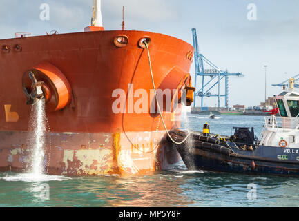 La petroliera di pompaggio di acqua di zavorra come rimorchiatore nave guide sulla banchina di ormeggio nel porto Foto Stock