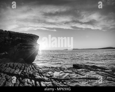 Rocce vicino Elgol, Loch Scavaig, Isola di Skye in Scozia. Caldi colori del tramonto nella fredda sera di febbraio. Fotografi popolare destinazione. Foto Stock