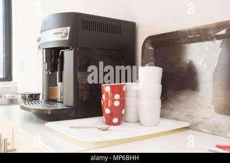 Macchina per caffè preparare caffè fresco e versando in red tazze al ristorante, bar o pub. Foto Stock