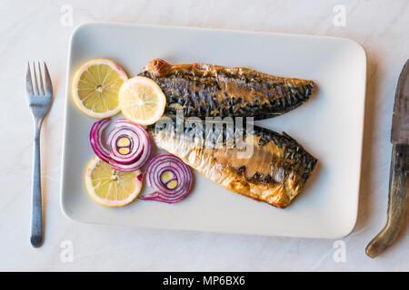 Sgombro pesce con le cipolle e i limoni nella piastra. Concetto di frutti di mare. Foto Stock