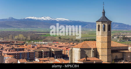 Panorama del campanile di una chiesa e di montagne dalle vette innevate nei pressi di Avila, Spagna Foto Stock