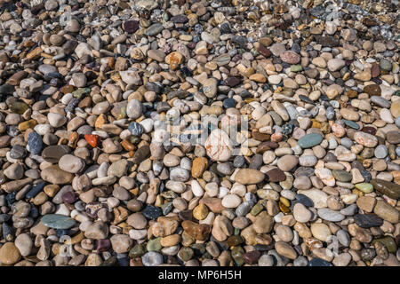 Le pietre colorate in acqua di mare sulla spiaggia in estate Foto Stock