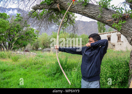 Ladakh, India - Luglio 18, 2015. Un uomo la riproduzione di tiro con l'arco al giardino in Ladakh, India. Ladakh è uno dei la maggior parte delle regioni scarsamente popolate in Jammu e Kash Foto Stock