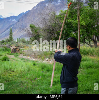 Ladakh, India - Luglio 18, 2015. Un uomo la riproduzione di tiro con l'arco al giardino in Ladakh, India. Ladakh è uno dei la maggior parte delle regioni scarsamente popolate in Jammu e Kash Foto Stock