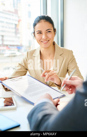 Sorridente giovane imprenditrice presentando contratto Foto Stock