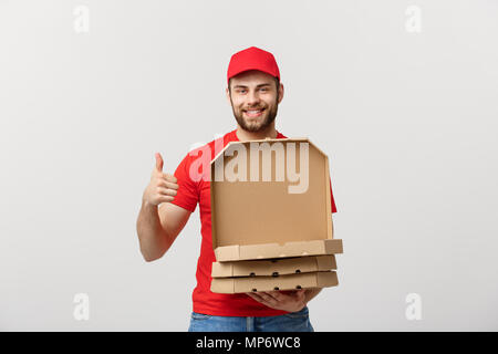 Consegna pizza concept. Ragazzo giovane è in grado di fornire e che mostra finestre di pizza in scatole. Isolato su sfondo bianco Foto Stock