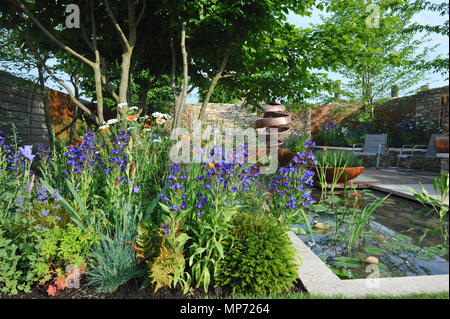 Londra, Regno Unito. 21 maggio 2018. La silenziosa piscina giardino Gin (disegnato da David Neale), uno dei più belli ed eleganti giardini mostra sul display a 2018 RHS Chelsea Flower Show che si è aperto oggi in 11 acri di giardini del Royal Hospital Chelsea, Londra, Regno Unito. La silenziosa piscina giardino Gin' è destinata ad un professionista giovane che vivono nella città e che richiedono uno spazio di fuga per rilassarsi e da una vita frenetica. Le caratteristiche principali includono il nativo di multi-derivava Crataegus monogyna, una contemporanea funzione di acqua con un infinity edge e una scultura in rame, al fianco di rame-laser taglio di pannelli wh Foto Stock