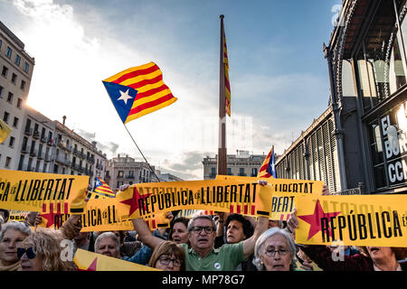 Un gruppo di dimostranti sono visti con manifesti pro repubblica di Catalogna con una bandiera di grandi dimensioni in background. Centinaia di persone hanno concentrato la protesta della manutenzione dell'articolo 155 che impedisce il normale funzionamento del governo catalano e istituzioni dopo la nomina del presidente Quim Torra. Foto Stock