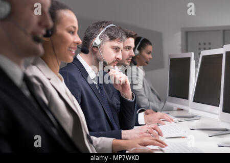 Team di agenti di call center durante il loro lavoro Foto Stock