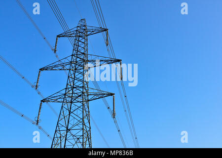 Elettricità pilone con più di cavi ad alta tensione e gli isolatori contro il cielo blu Foto Stock