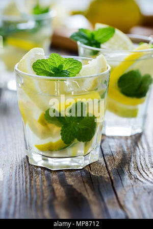 Fresca limonata fatta in casa con le fette di limone e menta fresca sul tavolo di legno Foto Stock