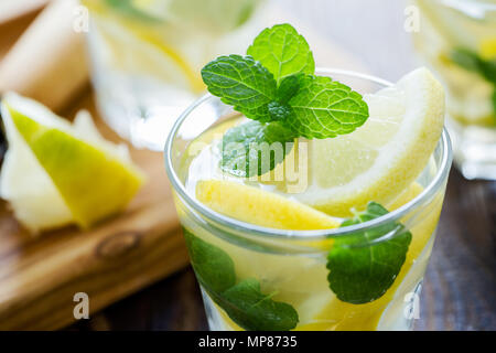 Fresca limonata fatta in casa con le fette di limone e menta fresca sul tavolo di legno Foto Stock