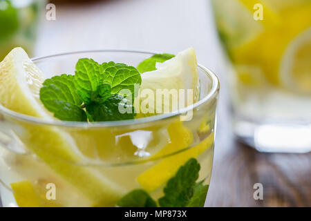 Fresca limonata fatta in casa con le fette di limone e menta fresca sul tavolo di legno Foto Stock