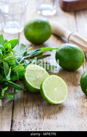 Ingredienti per rendere dissetante bevanda estiva cocktail mojito su tavola in legno rustico Foto Stock