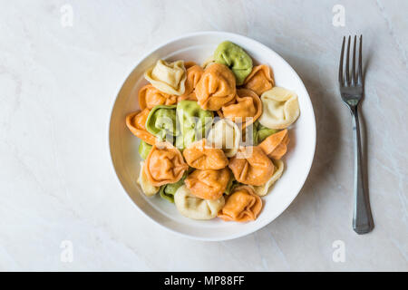 Tri colorato Tortellini / Multicolor o colorato. Il cibo italiano. Foto Stock