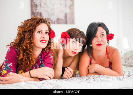 Belle donne giovani amici a casa a fissare il letto con una rosa nei capelli per stare insieme con allegria e divertimento. Il concetto di amicizia per Foto Stock