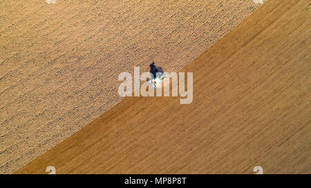 Foto aerea di un trattore arare un campo nella campagna francese Foto Stock