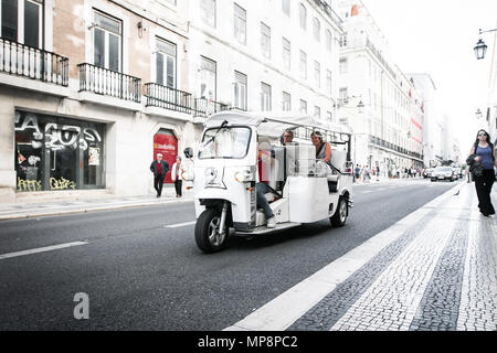 Lisbona, Portogallo, 5 Maggio 2018: turisti viaggiano da un tuk-tuk veicolo giù per una strada nel centro di Lisbona. Foto Stock