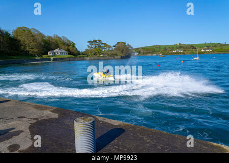 Giovane maschio a cavallo di un jet ski su una serata estati in porto castletownshend, Irlanda. Foto Stock