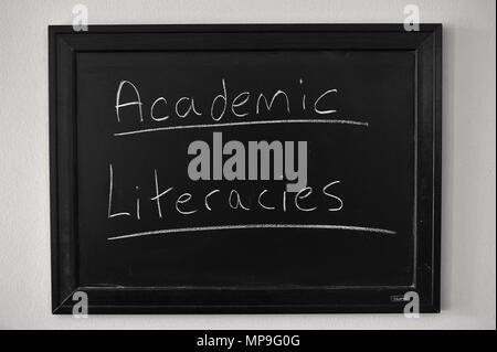 Academic Literacies scritto in bianco gesso su una parete montata Blackboard. Foto Stock