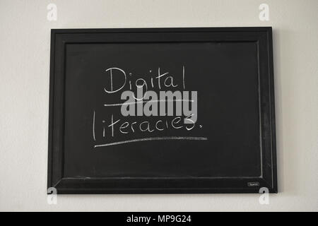 Digital literacies scritto in bianco gesso su una parete montata Blackboard. Foto Stock