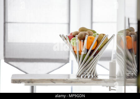 Frutti nel vaso di metallo sulla tavola, fresche melograno, pere, mele, mandarino Foto Stock