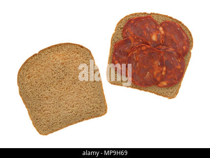 Vista superiore della salsiccia di maiale con fette di pane di grano con una fetta del lato isolato su uno sfondo bianco. Foto Stock