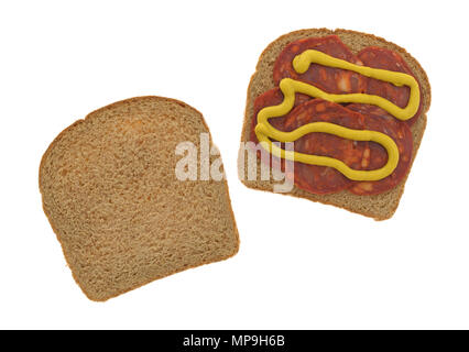Vista superiore della carne di maiale le fette di salsiccia con senape gialla sul pane di grano con una fetta del lato isolato su uno sfondo bianco. Foto Stock