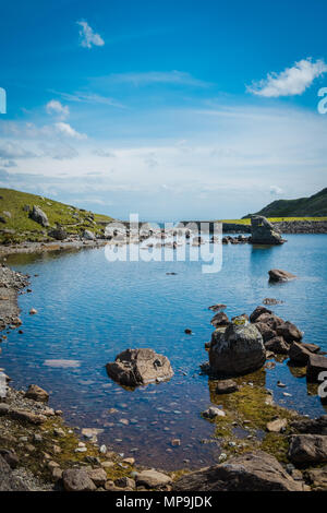 Un tarn che riflette il sole, accanto a "L'uomo vecchio di Coniston' nel distretto del lago, REGNO UNITO Foto Stock