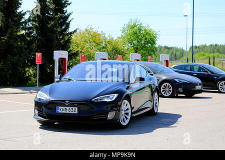 Tesla Model S driver Tesla lascia la stazione di sovralimentazione dopo la ricarica della batteria su un bel giorno di estate in Paimio, Finlandia - 20 maggio 2018. Foto Stock