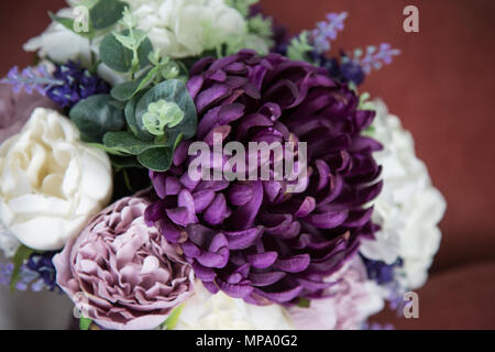 Close up di un bouquet spose il giorno delle nozze con fiori viola con il verde Foto Stock