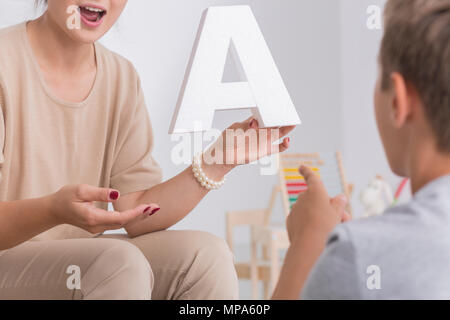 Inquadratura di un ragazzino avente un incontro con logopedista Foto Stock