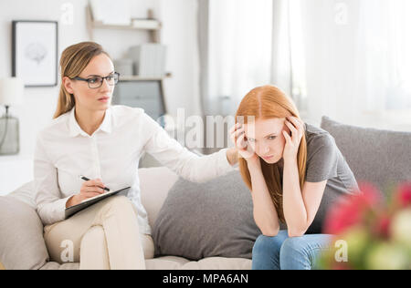 Giovane ragazza infelice forma di sofferenza ripartizione mentale durante la sessione con lo psichiatra Foto Stock