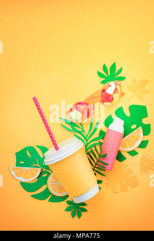 La vacanza estiva laici piatto con foglie tropicali, un drink rinfrescante, occhiali da sole e protezione solare su una soleggiata sfondo giallo con spazio di copia Foto Stock
