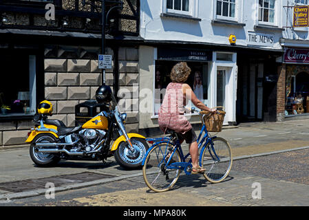 Donna ciclismo passato Harley Davidson Moto, St Ives, Cambridgeshire, England Regno Unito Foto Stock