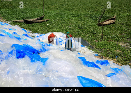 Le donne di asciugatura sacchetti di plastica per il riciclaggio sulle rive del fiume Buriganga a Dacca in Bangladesh Foto Stock