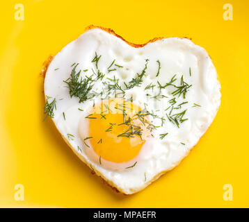 La prima colazione. Uova fritte a forma di cuore, con aneto Foto Stock