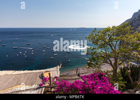 Positano, Italia - 12 Giugno 2017: Positano incorniciato da rosa bouganville e barche in background. Colorato Positano, la perla della Costiera Amalfitana, Foto Stock