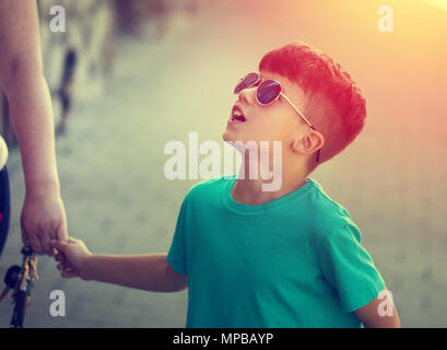Piccolo Ragazzo caucasico cercando fino al genitore, infanzia Foto Stock