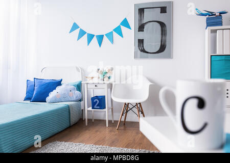 Perfetto progettato da letto con pareti bianche, pavimento in legno e gli elementi di colore blu ideale per ragazzo Foto Stock