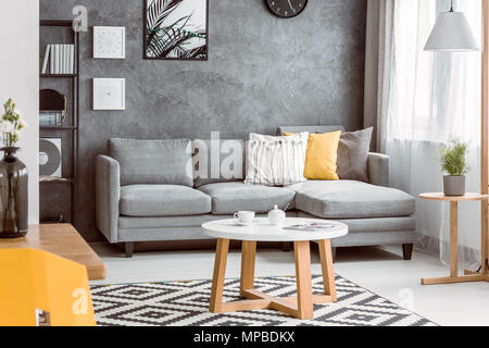 Divano giallo e bianco tavolino vicino alla parete luminosa Foto stock -  Alamy